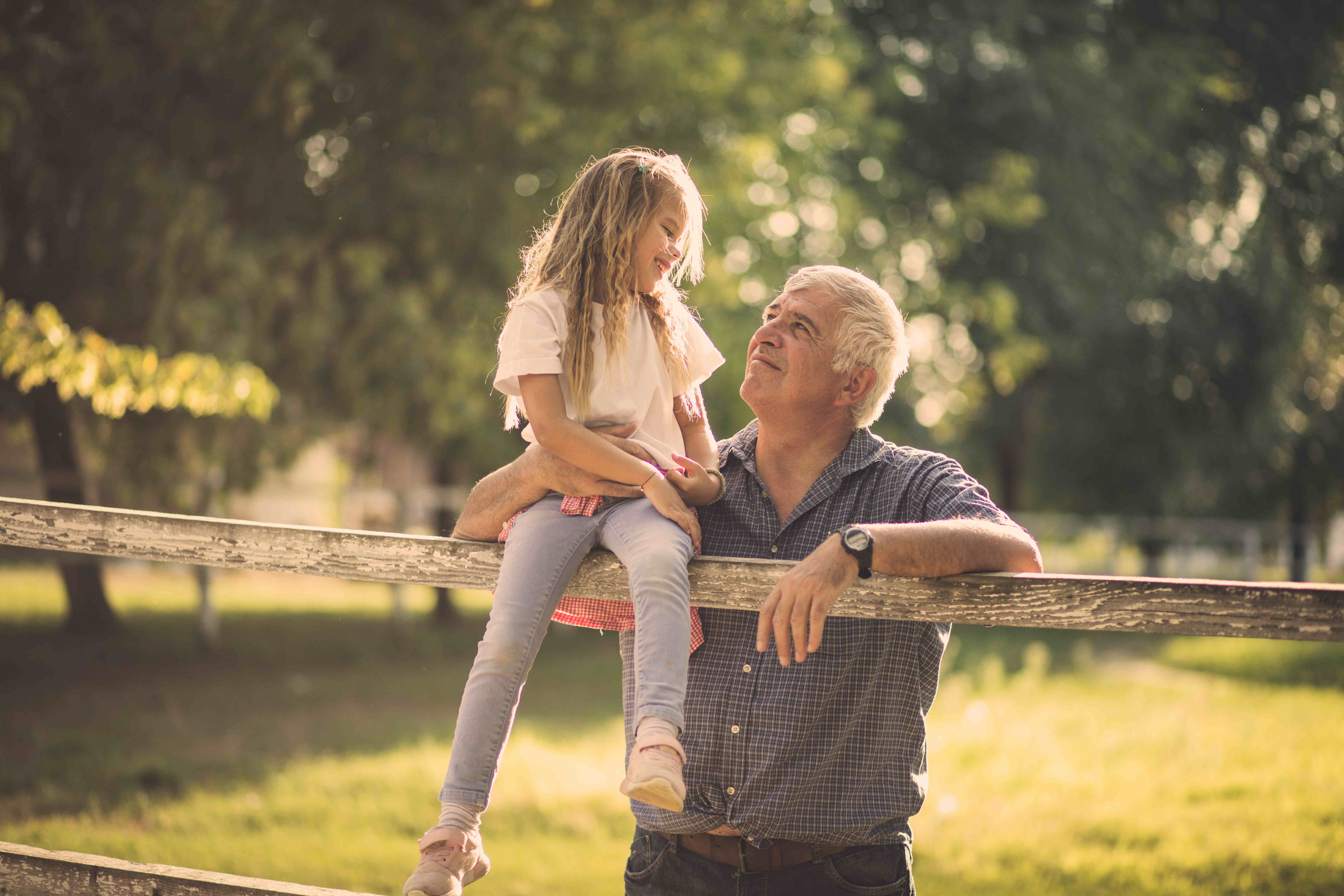 A grandfather and his granddaughter sharing a warm moment outdoors